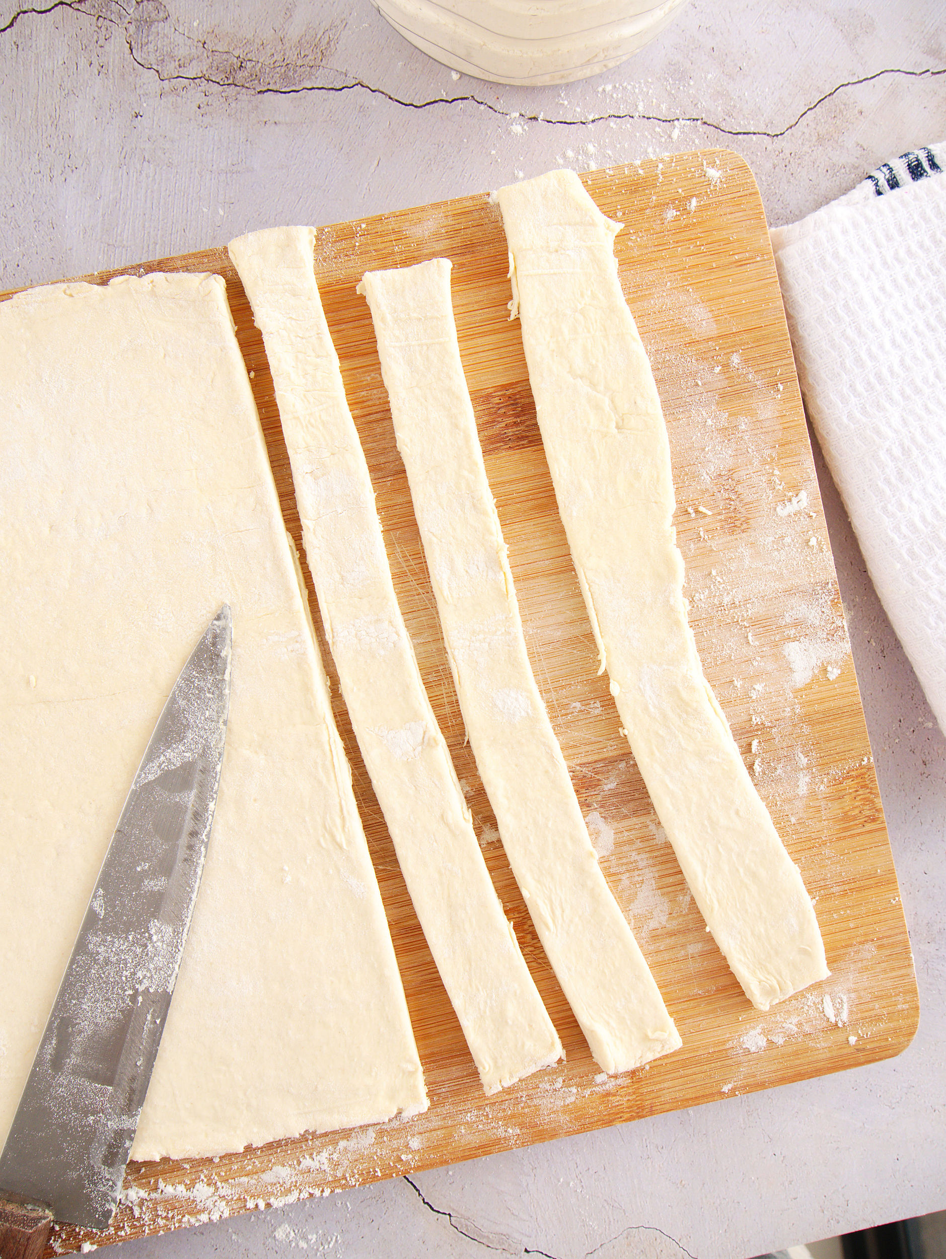 Use a sharp knife or pizza cutter to slice puff pastry into 1-inch strips for baked churros